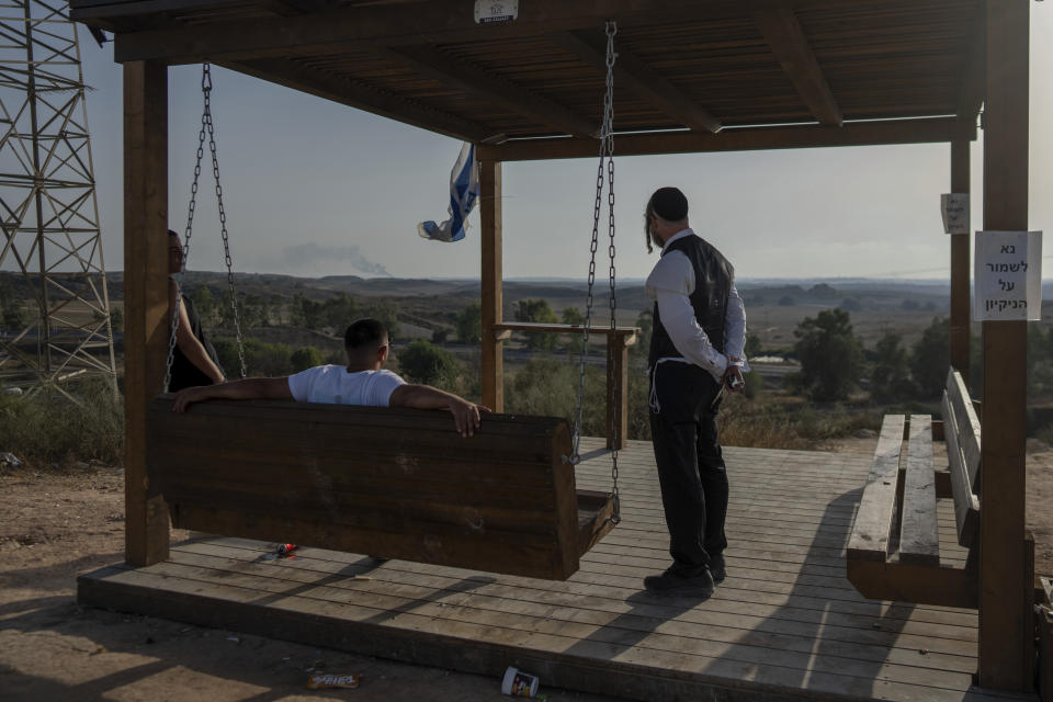 People look at the Gaza Strip from an observation point in the town of Sderot, southern Israel, on Thursday, June 20, 2024. A new kind of tourism has emerged in Israel in the months since Hamas’ Oct. 7 attack. For celebrities, politicians, influencers and others, no trip is complete without a somber visit to the devastated south that absorbed the brunt of the assault near the border with Gaza. (AP Photo/Ohad Zwigenberg)