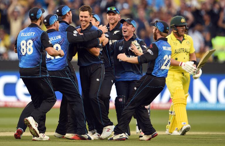 New Zealand fast bowler Trent Boult (C) is congratulated after dismissing Australia's Aaron Finch (R) during the Cricket World Cup final in Melbourne on March 29, 2015