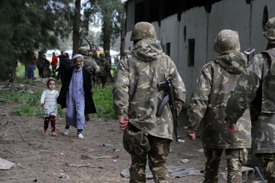 <p>Algerian soldiers and citizens walk near the site where a military transport aircraft crashed in Boufarik, about 30Kms south the capital Algiers, Algeria, April 11, 2018. (Photo: Farouk Batiche/Anadolu Agency/Getty Images) </p>