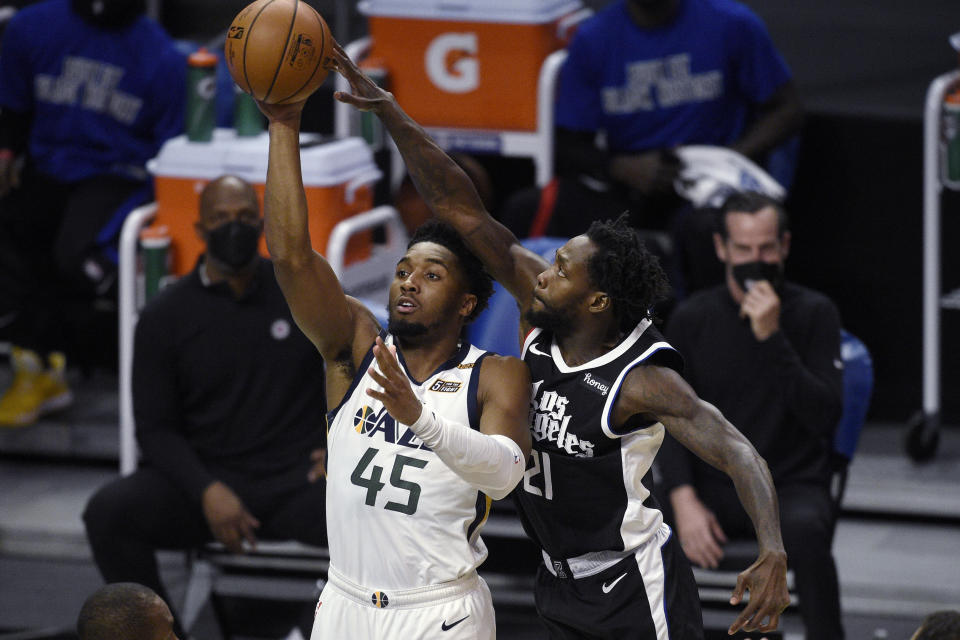 Utah Jazz guard Donovan Mitchell, left, shoots while pressured by Los Angeles Clippers guard Patrick Beverley during the first half of an NBA basketball game in Los Angeles, Friday, Feb. 19, 2021. (AP Photo/Kelvin Kuo)