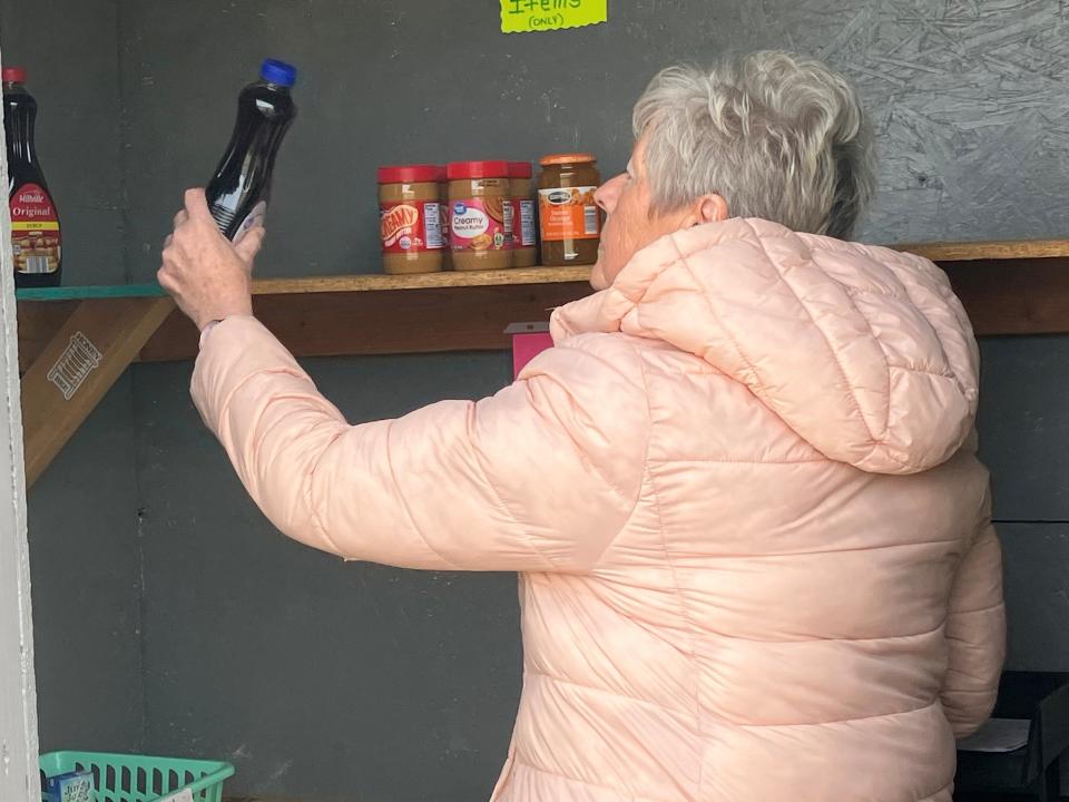 Cathy McGlone checks the stock at the Lexington Area Little Food Pantry on Friday morning.