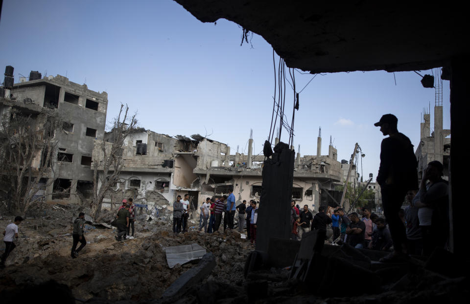 Palestinos revisando sus casas destruidas tras los ataques aéreos de la noche en la localidad de Beit Hanoun, en el norte de la Franja de Gaza, el viernes 14 de mayo de 2021. (AP Foto/Khalil Hamra)