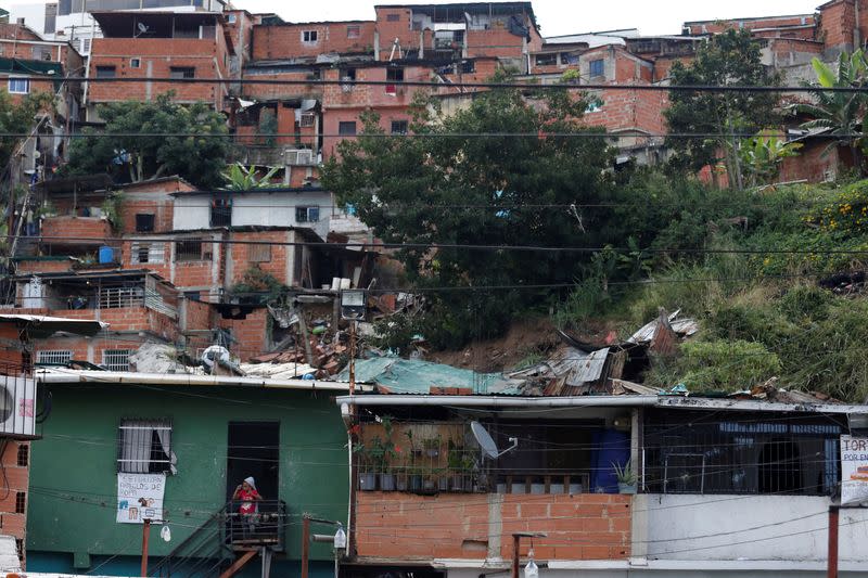 Una niña espera a ser evacuada a un refugio desde una zona de casas derrumbadas tras las fuertes lluvias, en Caracas