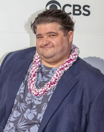 Jorge wearing a hawaiian lei and his hair slicked back