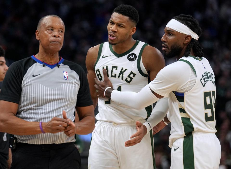 Bucks forward Giannis Antetokounmpo is held back by forward Jae Crowder while arguing a call during the first half of their game against the Detroit Pistons on Wednesday at Fiserv Forum.