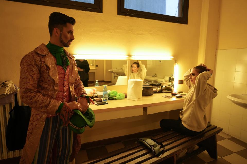 Oleksandr Bandaliuk, left, who plays the Mad Hatter, looks at his wife Yuliia, a dancer, before the show "Alice in Wonderland" in Pistoia, Italy, Friday, May 6, 2022. A Ukrainian circus troupe is performing a never-ending “Alice in Wonderland” tour of Italy. They are caught in the real-world rabbit hole of having to create joyful performances on stage while their families at home are living through war. The tour of the Theatre Circus Elysium of Kyiv was originally scheduled to end in mid-March. (AP Photo/Alessandra Tarantino)
