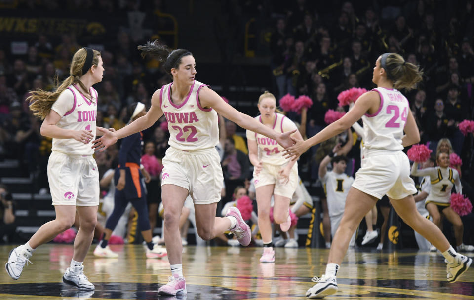 Iowa guard Caitlin Clark (22) celebrates a three point basket with Iowa guards Molly Davis, left, and Gabbie Marshall, right, during the first half of an NCAA college basketball game, Sunday, Feb. 25, 2024, in Iowa City, Iowa. (AP Photo/Cliff Jette)