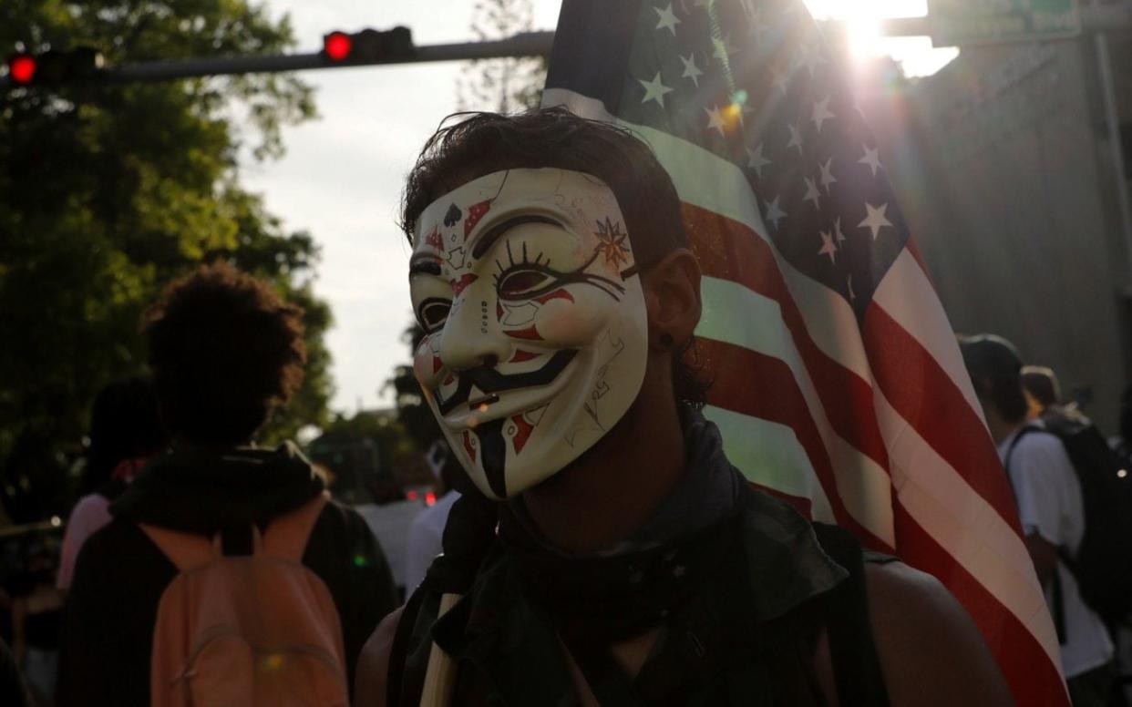 A protestor against the death of George Floyd wears a Guy Fawkes mask in Miami
