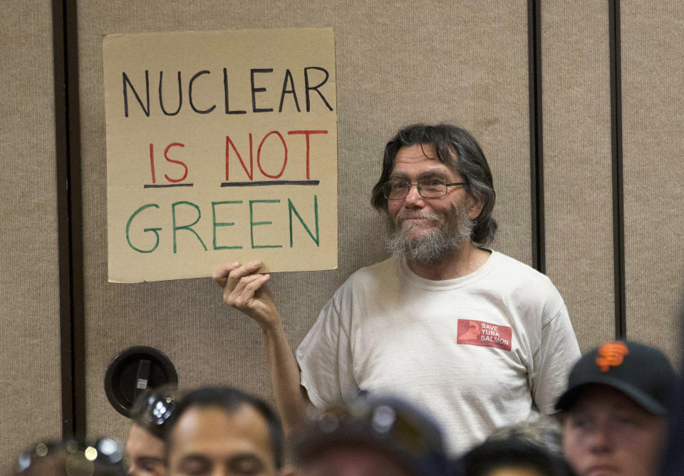 FILE - Peter Galbraith displays his opposition to a proposal to waive an environmental review of the Diablo Canyon Nuclear Power plant before renewing the plant's license, Tuesday, June 28, 2016, in Sacramento, Calif. As climate change pushes states in the U.S. to dramatically cut their use of fossil fuels, many are coming to the conclusion that solar, wind and other renewable power sources won't be enough to keep the lights on. Nuclear power is emerging as an answer to fill the gap as states transition away from coal, oil and natural gas to reduce greenhouse gas emissions and stave off the worst effects of a warming planet. (AP Photo/Rich Pedroncelli, File)