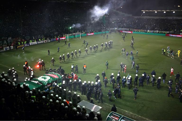 Riot police enter the pitch during the football game between Athens arch-rivals Olympiakos and Panathinaikos on February 22, 2015 in Athens