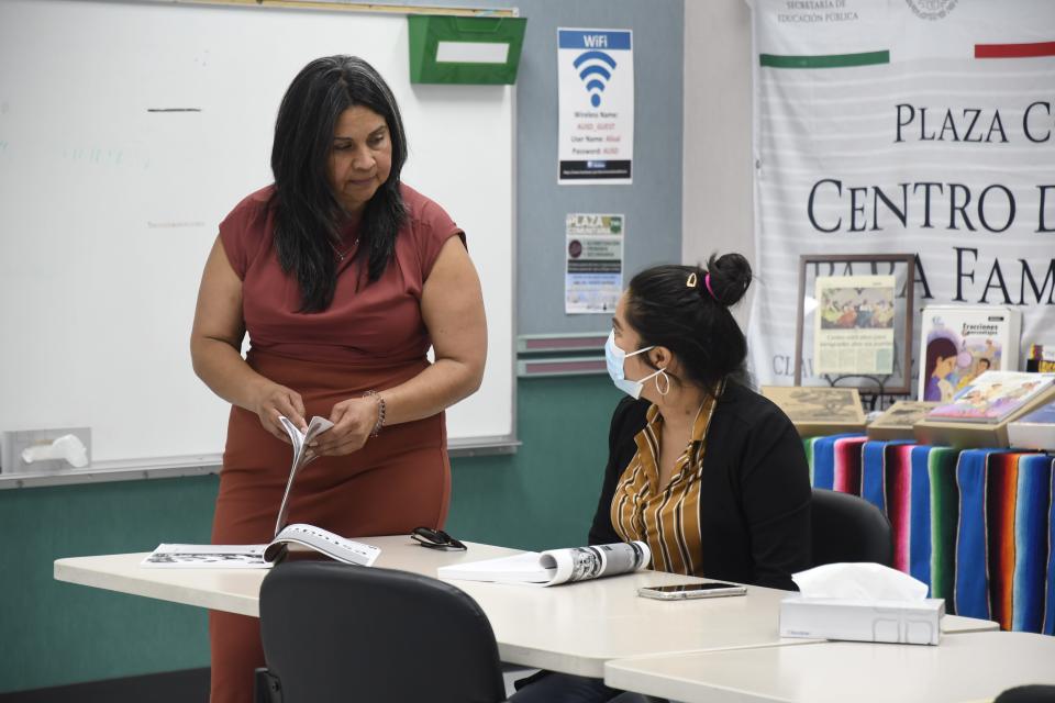 Teacher Oralia Villanueva assists a student in her Plaza Comunitaria class for Spanish speakers at the Alisal Family Resource Center in Salinas, Calif.