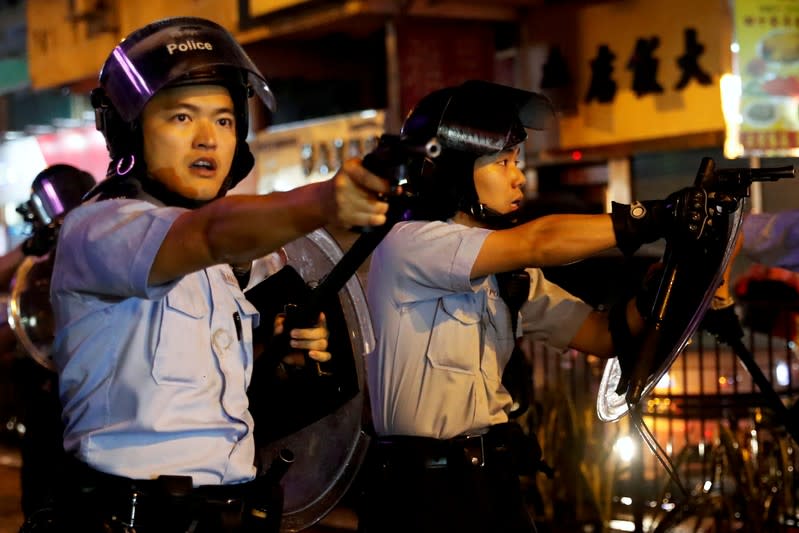 FILE PHOTO: Police officers point their guns towards anti-extradition bill protesters after a clash, at Tsuen Wan, in Hong Kong