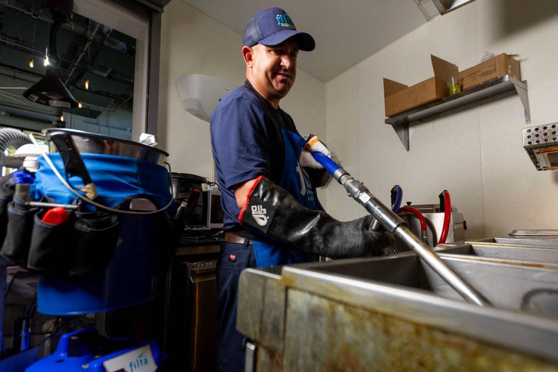 Filta service technician Richard Erin uses the vacuum-based filtration system to clean a deep fryer at Cerveceria La Tropical in Miami's Wynwood neighborhood on Wednesday, May 24, 2023.