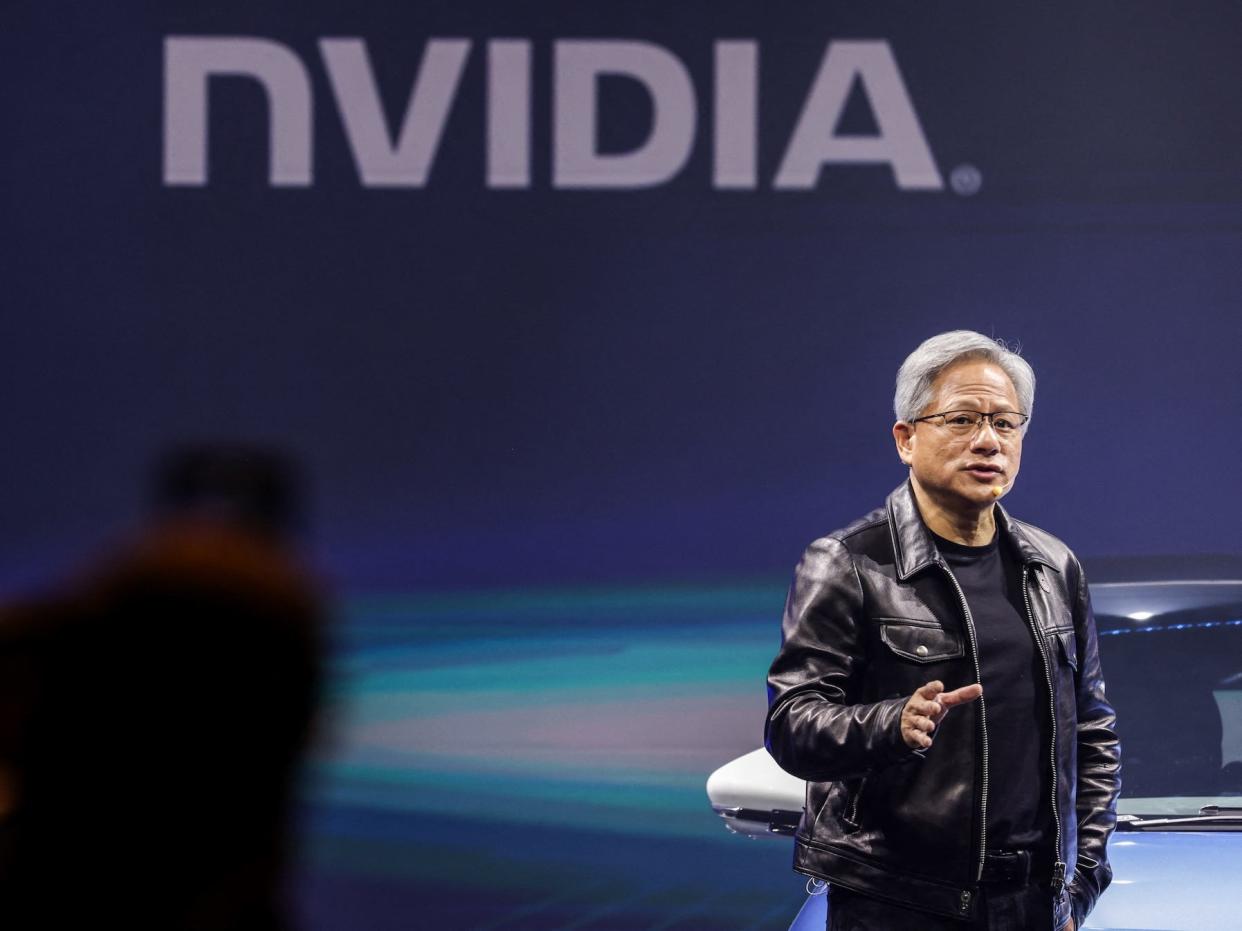 Jensen Huang talking in front of a Nvidia logo.