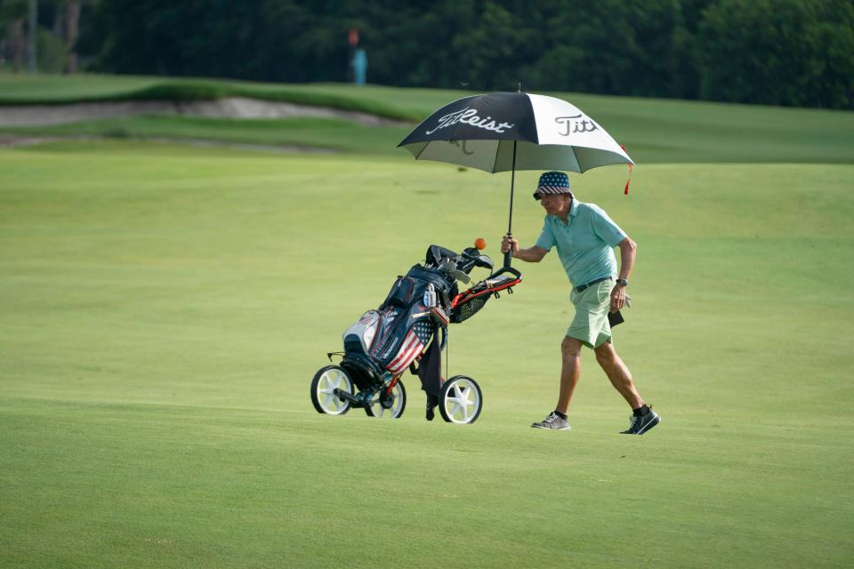 Shelton Hochstedler pushes his golf clubs around the course during a round of golf at The Park in West Palm Beach, Florida on June 30, 2023.