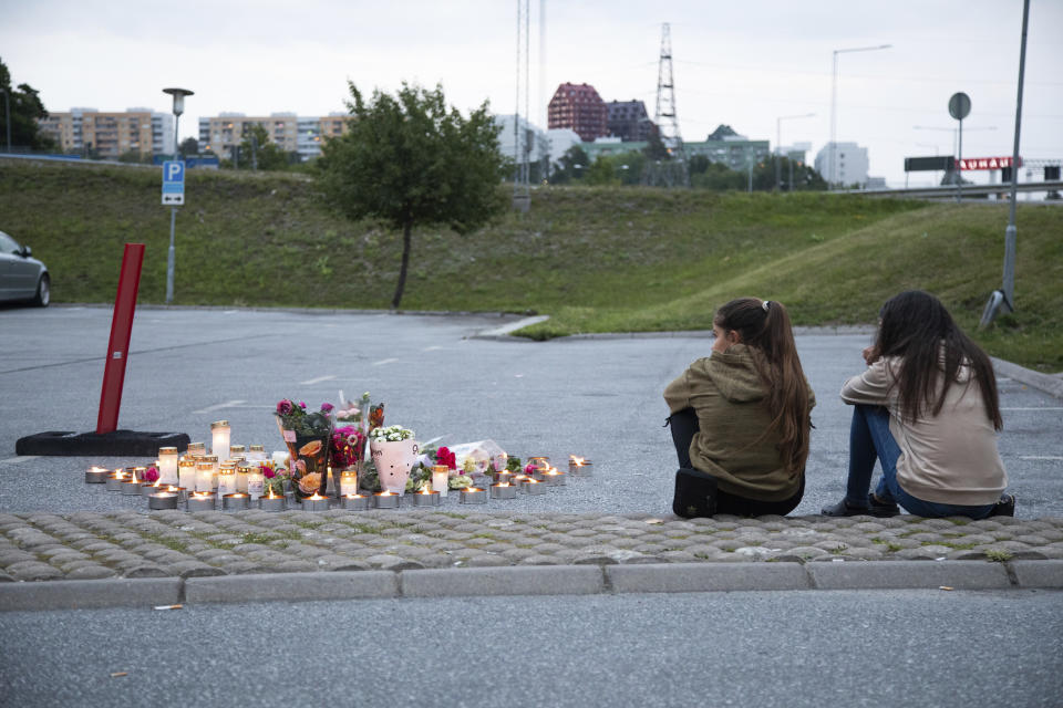 Flowers and candles are placed Sunday Aug. 2, 2020 near where a twelve-year-old girl was shot and killed near a petrol station in Botkyrka, south of Stockholm, Sweden. (Ali Lorestani//TT via AP)