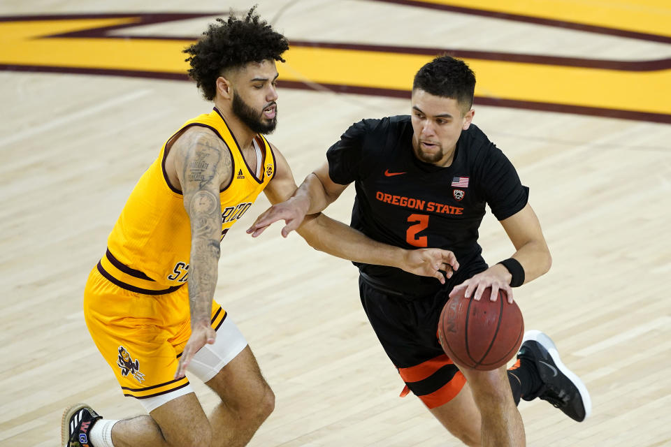 Oregon State guard Jarod Lucas (2) drives as Arizona State guard Holland Woods defends during the first half of an NCAA College basketball game, Sunday, Feb. 14, 2021, in Tempe, Ariz. (AP Photo/Matt York)