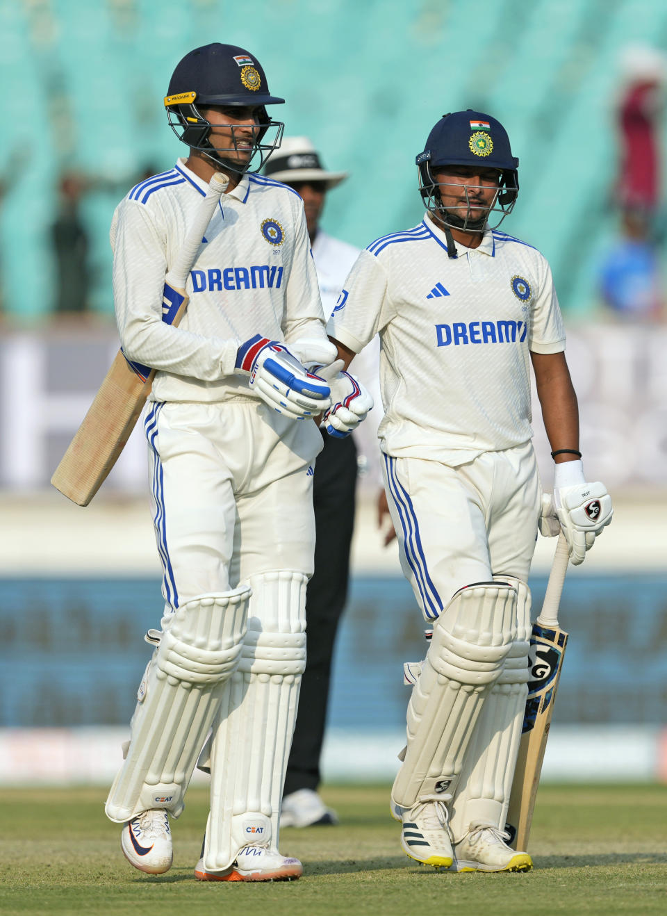 India's Shubman Gill, left, and Kuldeep Yadav walk back to the pavilion at the end of the third day of the third cricket test match between England and India in Rajkot, India, Saturday, Feb. 17, 2024. (AP Photo/Ajit Solanki)