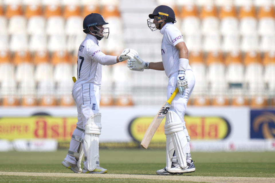 England's Ben Duckett, left, and Joe Root bumps their fists to celebrate their hundred runs partnership during the third day of the first test cricket match between Pakistan and England, in Multan, Pakistan, Wednesday, Oct. 9, 2024. (AP Photo/Anjum Naveed)