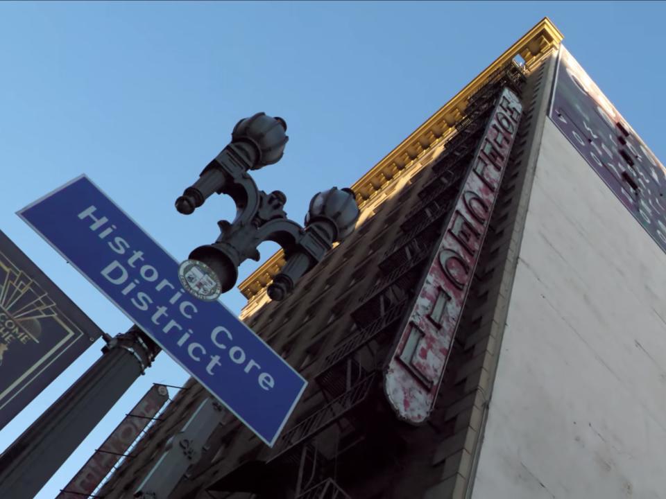 Street level point of view looking up at Cecil Hotel and Historic Core District sign.