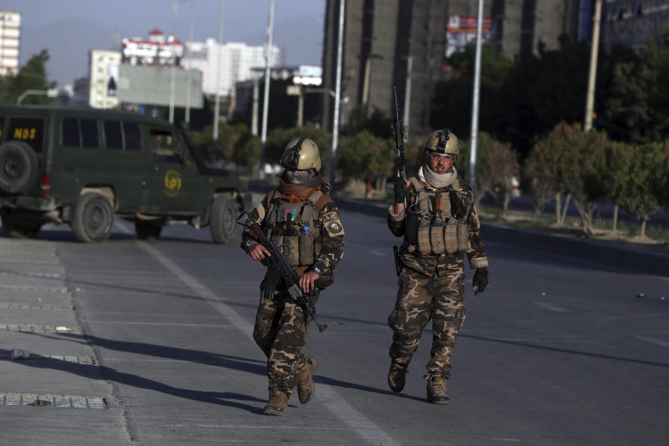 Afghan security forces inspect the site where a bus carrying local TV station employees hit a roadside bomb in Kabul, Afghanistan, Saturday, May 30, 2020. (AP Photo/Rahmat Gul)