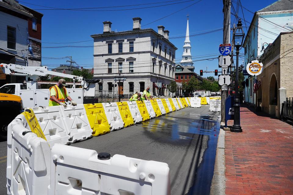 In this June 18, 2020, photo, Portsmouth Public Works employees, from left, Jim Carr, Jeff Boucher and Glenn Kelleher, set up barriers to create outdoor dining for the Clipper Tavern on Pleasant Street.