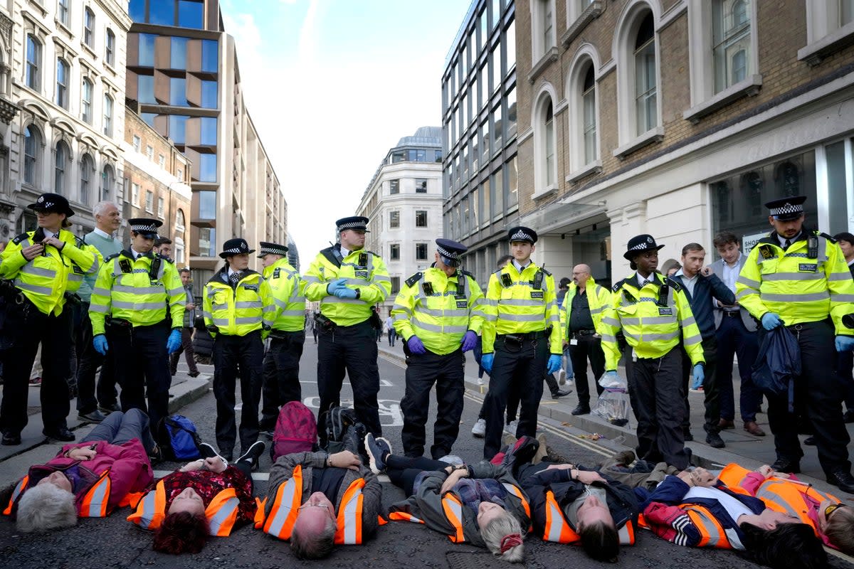 Handcuffed activisits from the group Just Stop Oil lie on the road as they are arrested after they blocked a road in London,  (AP)