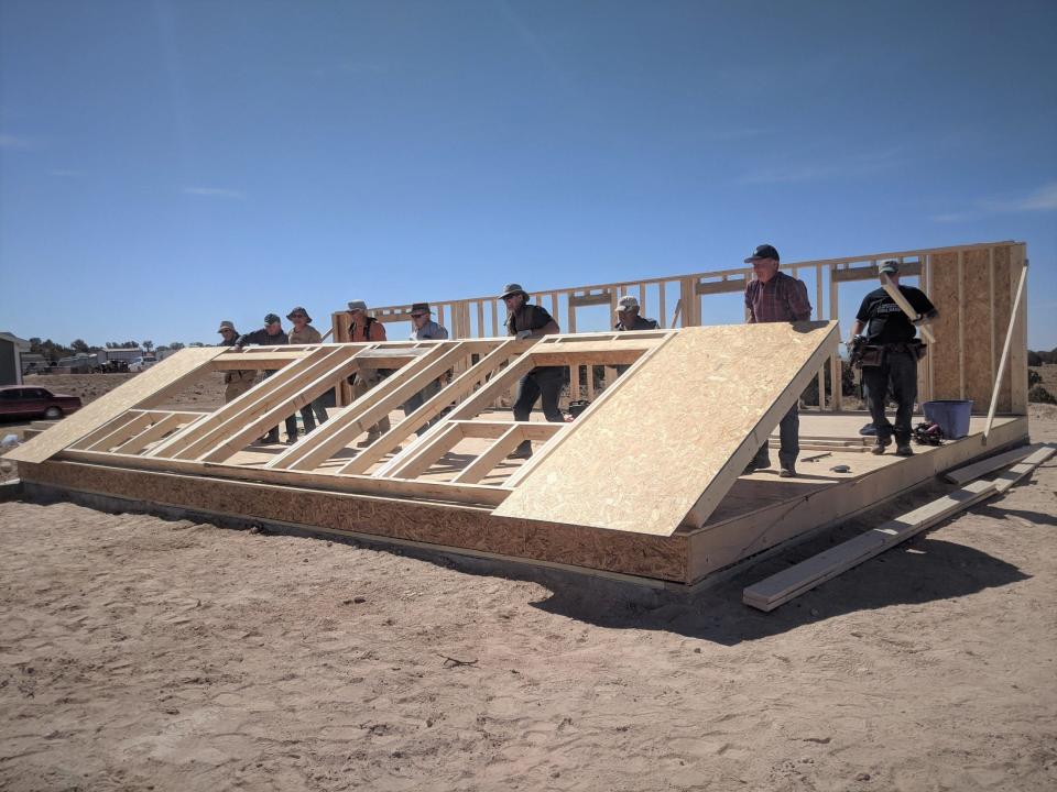 File photo - Tres Rios Habitat for Humanity volunteer workers lift a wall in place for a home in San Juan County.