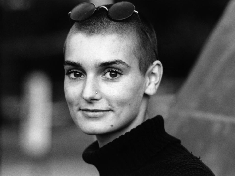 Sinéad O'Connor smiling with sunglasses on her head