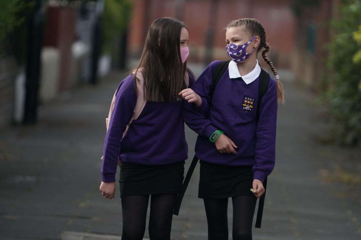 <p>Kadie Lane (right), 11, and Brooke Howourth, 11, walking to Marden Bridge Middle School in Whitley Bay, Tyne and Wear</p> (PA)