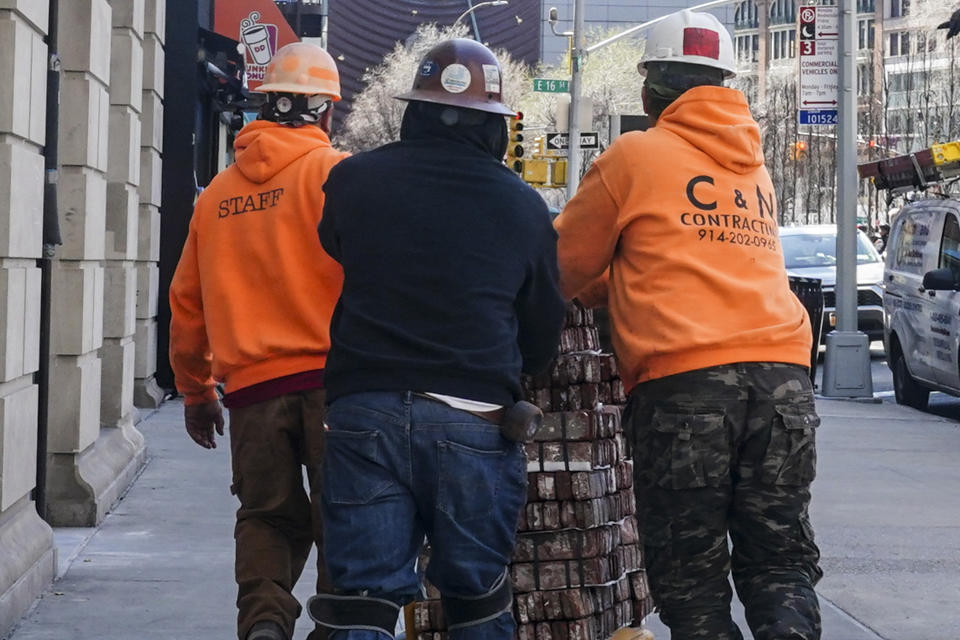 File - Construction workers push a cart of bricks on Wednesday March 29, 2023, in New York. On Friday, the U.S. government issues the May jobs report. The labor market has added jobs at a steady clip in the past year, despite efforts by the Federal Reserve to cool the economy and bring down inflation. (AP Photo/Bebeto Matthews, File)