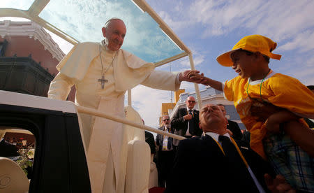 Pope Francis greets a child as he arrives to lead the Marian celebration of the Virgin de la Puerta in Trujillo, Peru, January 20, 2018. REUTERS/Douglas Juarez