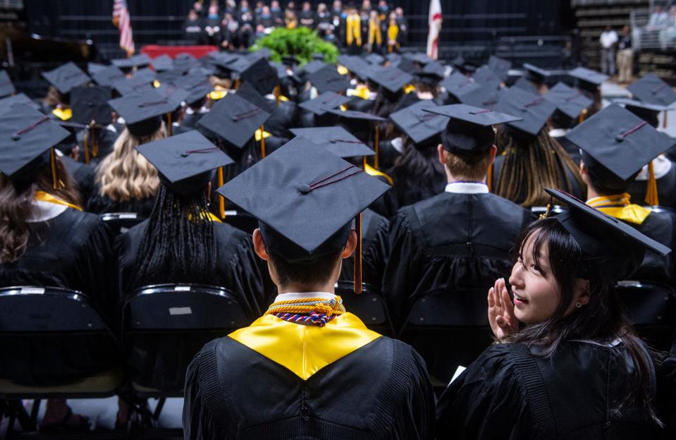 Stacey Suela Yoo waves to friends and family during LAMP graduation ceremony at Dunn-Oliver Acadome in Montgomery, Ala., on Tuesday, May 16, 2023.