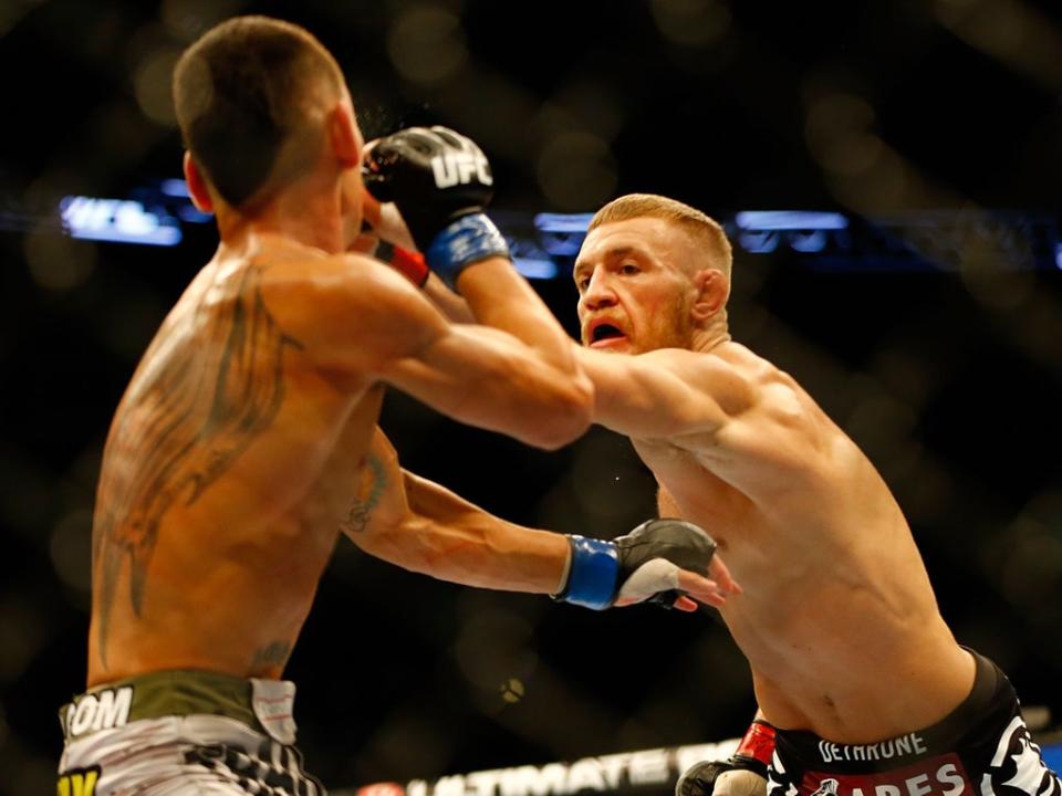 Conor McGregor punches Max Holloway in their featherweight bout at TD Garden (Getty )