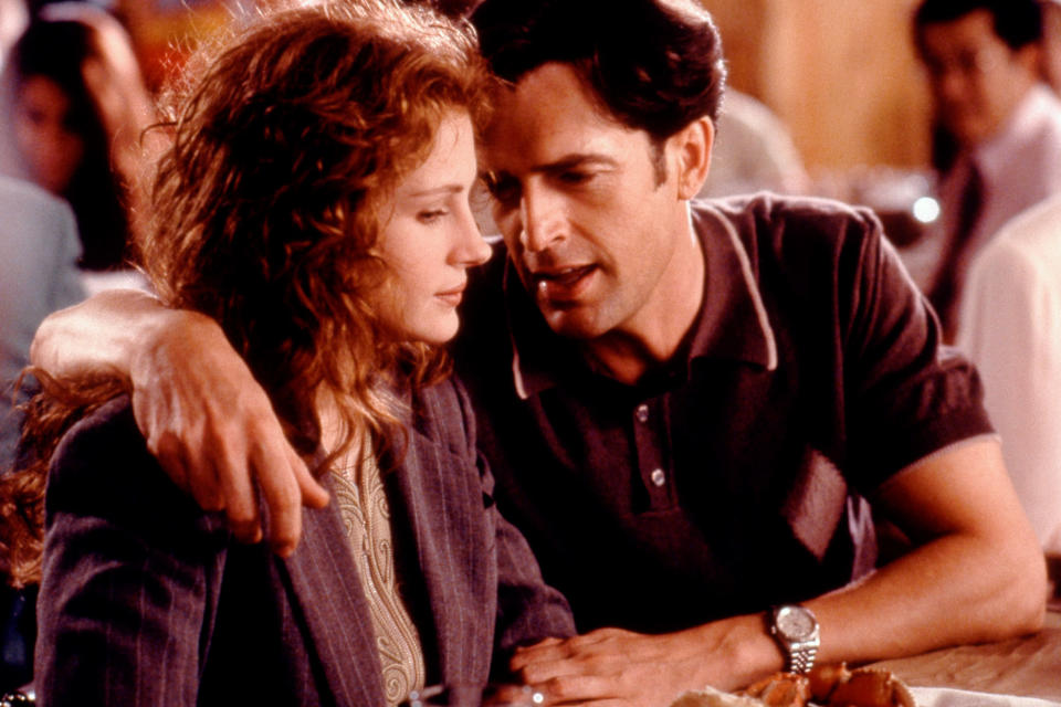 Julia Roberts and Rupert Everett sitting side by side, with Rupert's arm around Julia's shoulders