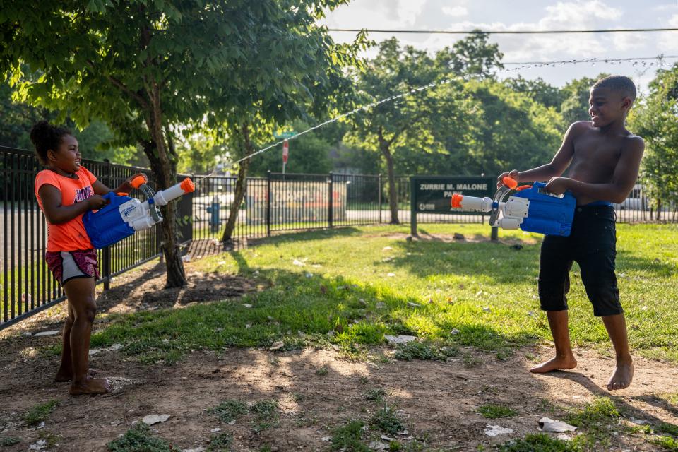 Cousins Nai Nai, 5, and CJ Roberts, 7, have a water gun fight at a park near their home on June 10, 2022 in Houston, Texas. Texas is under a heatwave alert.