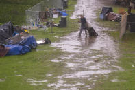 A man drags belongings through a homeless encampment at Riverwalk Park in Santa Cruz, Calif., Monday, Dec. 13, 2021. A major storm hitting Northern California is expected to intensify and bring travel headaches and a threat of localized flooding after an abnormally warm fall in the U.S. West. (AP Photo/Nic Coury)