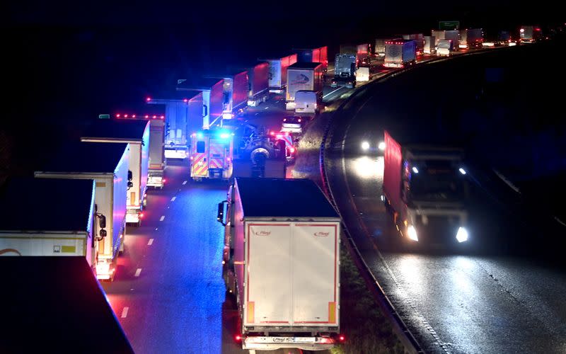 An emergency vehicle drives as lorries queue to enter the Port of Dover