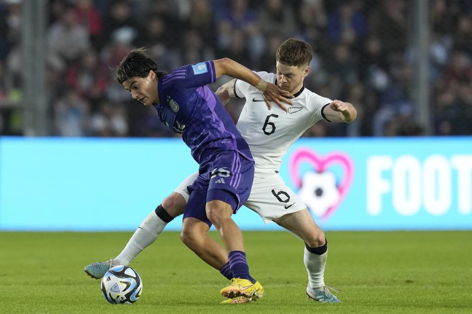 Luka Romero de Argentina, izquierda, Fin Conchie de Nueva Zelanda disputan la pelota durante un partido del Grupo A del Mundial Sub20 en el estadio Bicentenario de San Juan, Argentina, 26 de mayo, 2023. (AP Foto/Natacha Pisarenko)