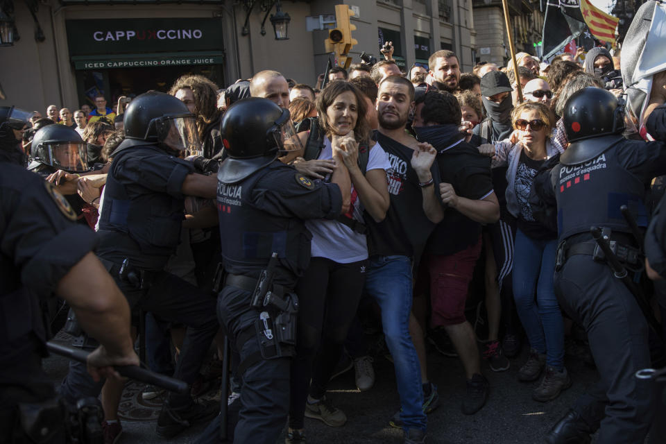 Catalan police officers clash with pro independence demonstrators on their way to meet a demonstrations by member and supporters of National Police and Guardia Civil in Barcelona on Saturday, Sept. 29, 2018. (AP Photo/Emilio Morenatti)