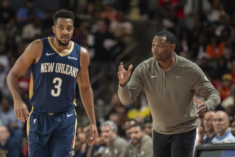 New Orleans Pelicans head coach Willie Green, right, speaks to guard CJ McCollum (3) during the first half of a preseason NBA basketball game against the Atlanta Hawks, Saturday, Oct. 14, 2023, in College Park, Ga. (AP Photo/Hakim Wright Sr.)