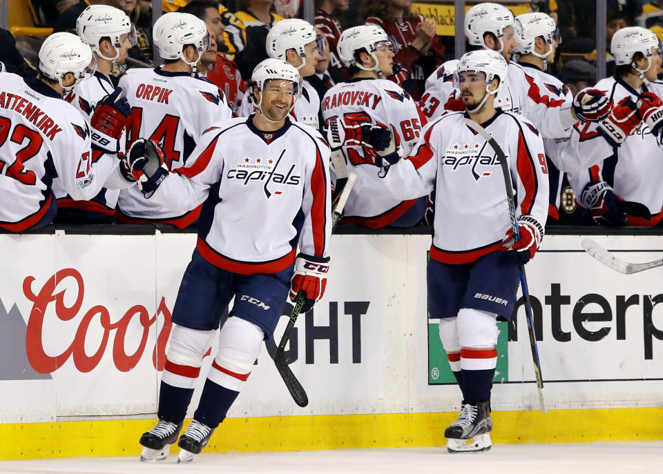 Washington Capitals' Justin Williams, left, and Dmitry Orlov (9) are congratulated at the bench after Williams scored against the Boston Bruins during the second period of an NHL hockey game in Boston, Saturday, April 8, 2017. (AP Photo/Winslow Townson)