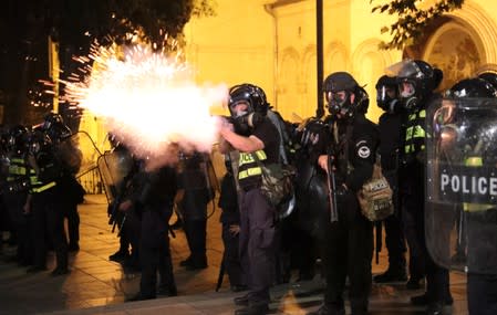 A policeman fires during a rally against a Russian lawmaker's visit in Tbilisi