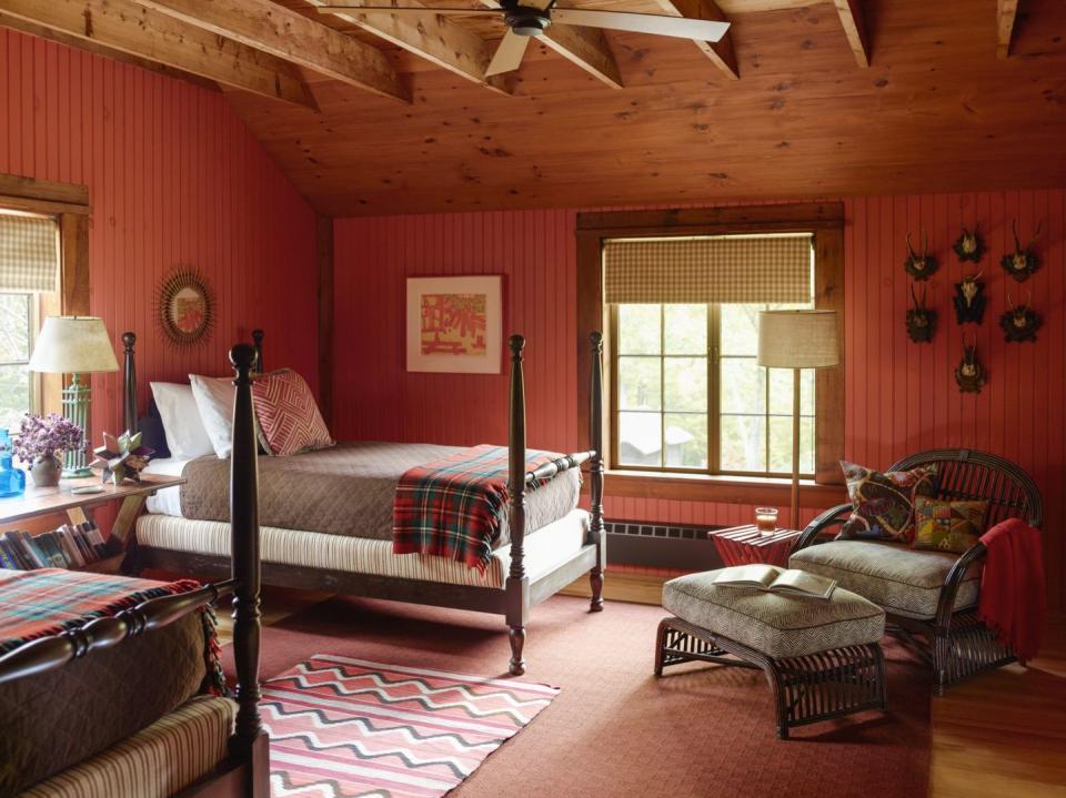 <p>This guest bedroom in New Hampshire exudes rustic charm. The space from <a href="https://deringhall.com/interior-designers/heather-wells-inc" rel="nofollow noopener" target="_blank" data-ylk="slk:Heather Wells;elm:context_link;itc:0;sec:content-canvas" class="link ">Heather Wells</a> features red paneled walls, plaid fabrics, and dark wood accents.</p>