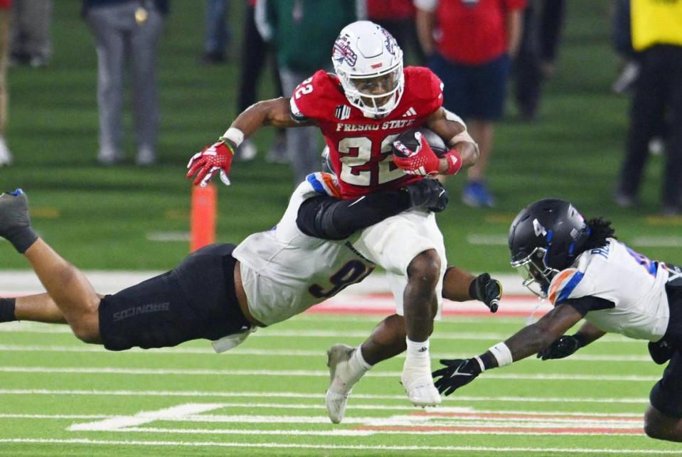 Fresno State running back Malik Sherrod, center, tries to find an opening between Boise State’s Ahmed Hassanein, left, and Rodney Robinson, right, in the Battle of the Milk Can Saturday, Nov. 4, 2023 in Fresno.