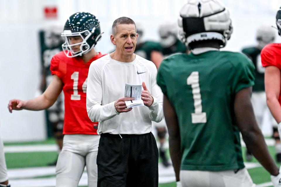 Michigan State's offensive coordinator Jay Johnson, left, talks with Jayden Reed during practice on Tuesday, March 29, 2022, at the indoor football facility in East Lansing.