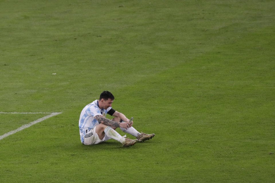 Argentina's Lionel Messi speaks on the phone after the Copa America final soccer match at Maracana stadium in Rio de Janeiro, Brazil, Saturday, July 10, 2021. Argentina beat Brazil 1-0. (AP Photo/Silvia Izquierdo)