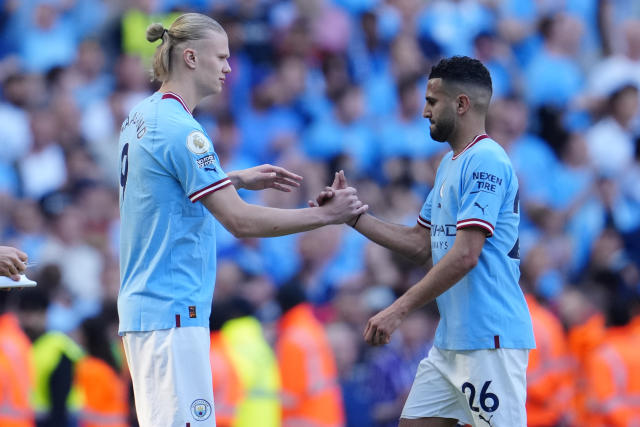 Manchester City's Erling Haaland, left, substitutes Manchester City's Riyad Mahrez during the English Premier League soccer match between Manchester City and Chelsea at the Etihad Stadium in Manchester, England, Sunday, May 21, 2023. (AP Photo/Jon Super)