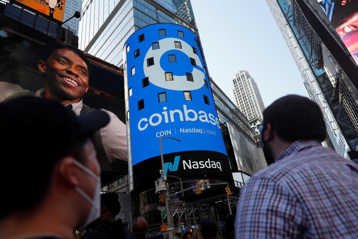 People watch as the logo for Coinbase Global Inc, the biggest U.S. cryptocurrency exchange, is displayed on the Nasdaq MarketSite jumbotron at Times Square in New York, U.S., April 14, 2021. REUTERS/Shannon Stapleton