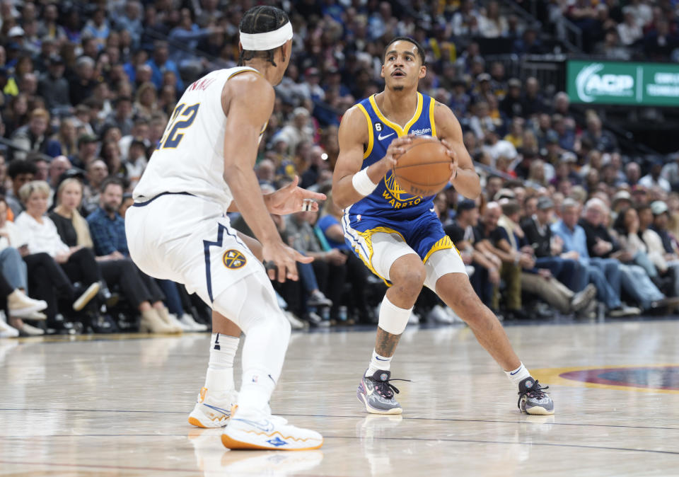 Golden State Warriors guard Jordan Poole, right, shoots the ball over Denver Nuggets forward Zeke Nnaji in the second half of an NBA basketball game Thursday, Feb. 2, 2023, in Denver. (AP Photo/David Zalubowski)